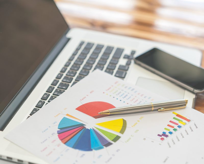 Financial charts on the table with laptop